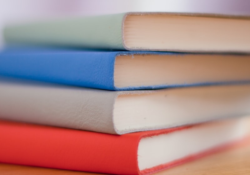 A stack of soft-cover exercise books in four colours